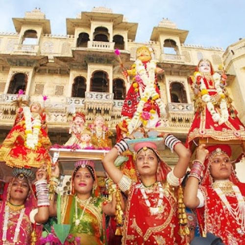 Women carrying decorated Gangaur idols during a colorful procession in Jaipur